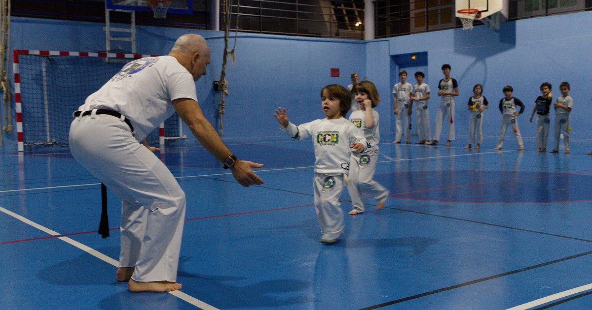 Un professeur accueille un enfant de trois ans en cours de capoeira
